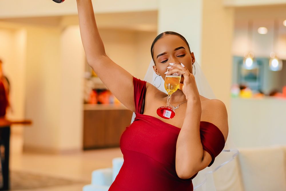 Mulher de vestido vermelho celebrando com taça de espumante