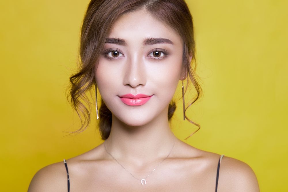 Mulher com visual elegante em fundo amarelo vibrante